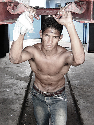 Shirtless man holding car lift